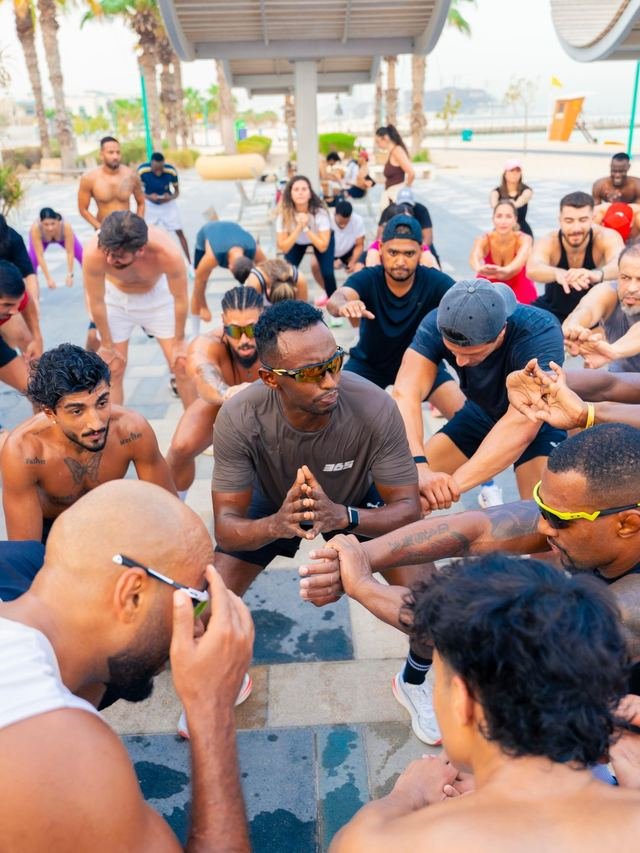 Nasir Hassan in a circle huddle with Collective 365 members