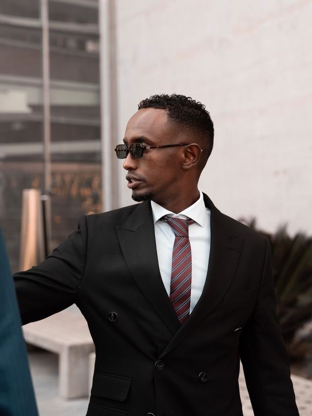 Nasir Hassan in a dark suit and tie in Barcelona